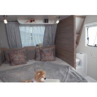 Het tweepersoonsbed in de lengte biedt volop ruimte en comfort. Ernaast de natte ruimte. Erboven een modern en handig opbergvak. afbeelding